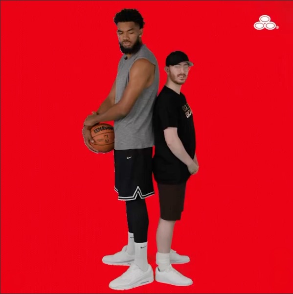 Karl-Anthony Towns holding a basketball on a State Farm red backdrop.