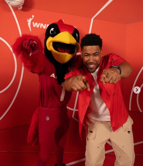 A State Farm team member posing with the WNBA cardinal mascot.